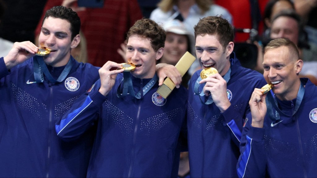 why do olympic swimmers wear coats swimming 2024