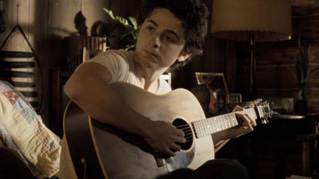 Timothee Chalamet strums the guitar in A Complete Unknown.