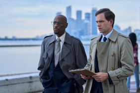 Two men stand outside the water.