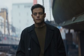 Rami Malek stands and stares.