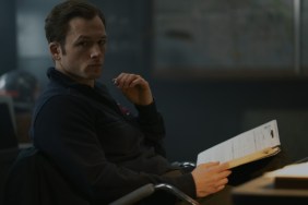 Taron Egerton holds a book.