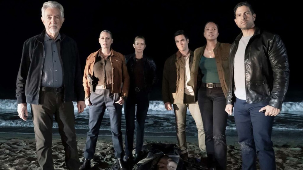 A group of cops stand on a beach.