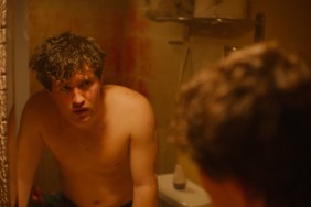 A boy stares into a mirror.