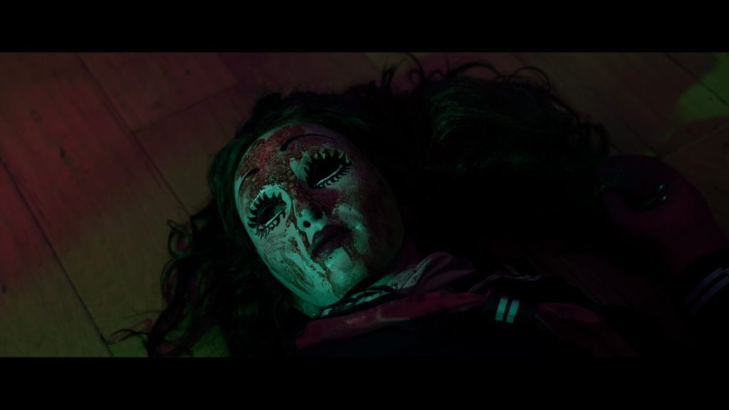 A killer doll with a bloody mask in Morgan: Killer Doll.